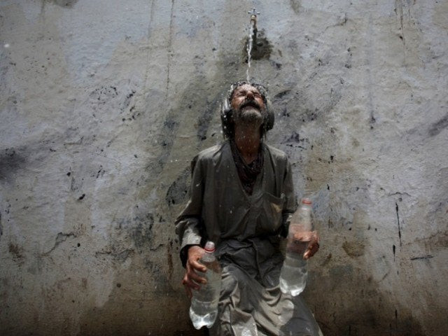 a man cools off under a public tap in karachi photo reuters a man cools off under a public tap in karachi photo reuters