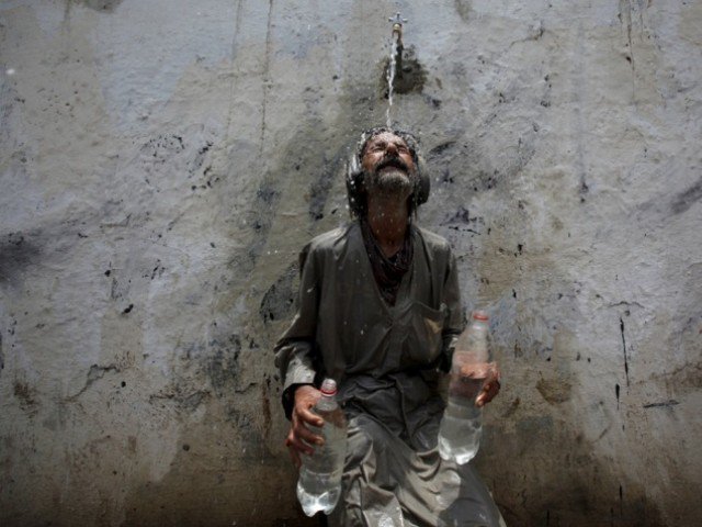 a man cools off under a public tap in karachi photo reuters