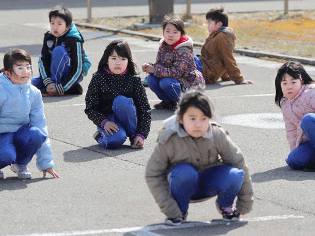 elementary school students squat down on the street as they participate in an evacuation drill for local residents based on the scenario that a ballistic missile launched landed in japanese waters in oga akita prefecture japan march 17 2017 photo reuters