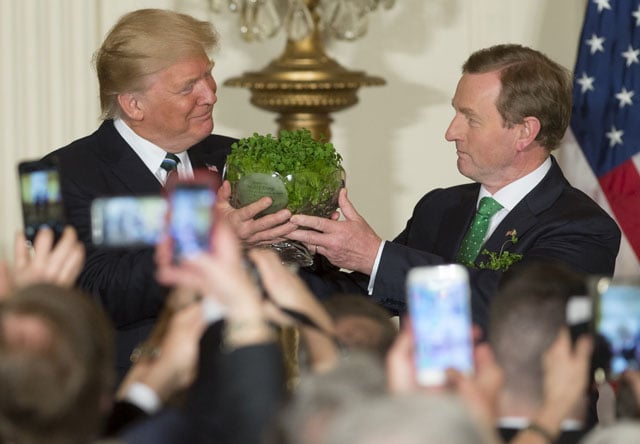 us president donald trump receives a traditional bowl of shamrocks from taoiseach of ireland enda kenny r during a st patrick s day reception in the east room of the white house in washington dc march 16 2017 photo afp