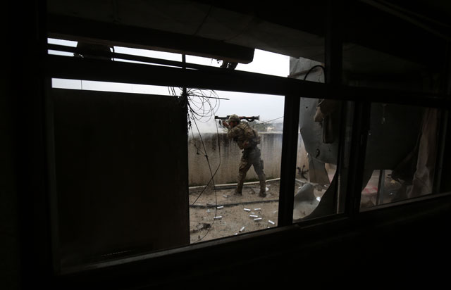 a member of the iraqi forces consisting of the iraqi federal police and the elite rapid response division fires a rocket propelled grenade towards islamic state is group jihadists as they advance in the old city in western mosul on march 19 2017 during the offensive to retake the city from is group fighters photo afp