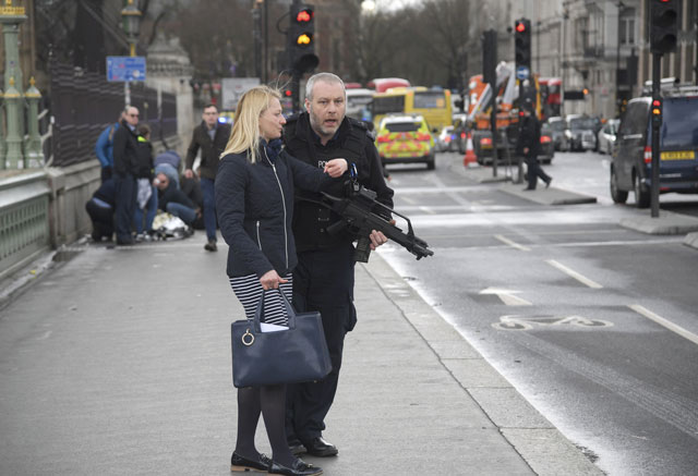 an armed police officer assists a woman after an incident on westminster bridge in london march 22 2017 photo reuters