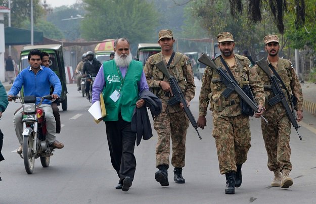 soldiers walk with an official l from the pakistan bureau of statistics as they arrive in a residential area to collect information for a census in lahore on march 15 2017 photo afp