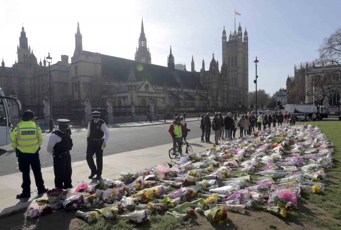 police officers look at floral tributes in parliament square following the attack in westminster earlier in the week in london britain march 25 2017 photo reuters