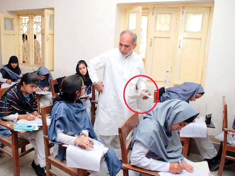 in the file photo above board of education sukkur examination controller mehmoodul hasan khokar is seen confiscating cheating material from students photo file