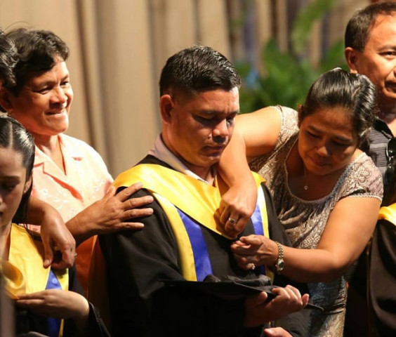 saint theresa 039 s college security guard erwin macua graduates with a bachelor 039 s degree in elementary education he receives his hood from his mother and his cap from his wife irenea during the graduation rites photo facebook via cebu daily news