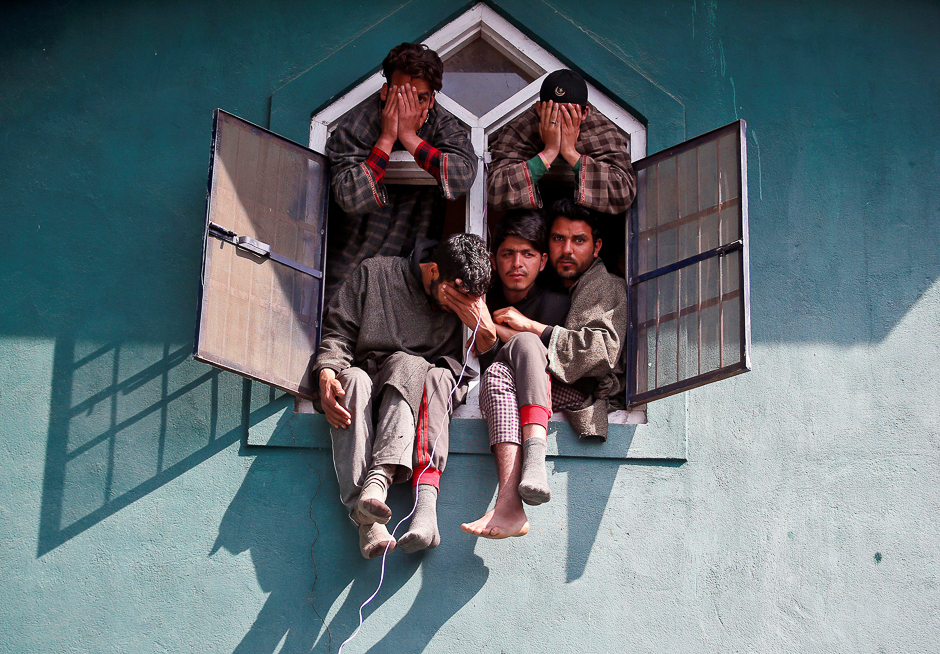 people react as they sit in a window of a mosque during the funeral of tauseef ahmad wagay a suspected militant who according to local media was killed in a gun battle with indian army on tuesday in chadoora in yaripora in south kashmir 039 s kulgam district photo reuters