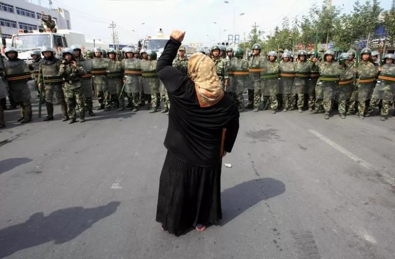 a local woman on a crutch shouts at chinese paramilitary police wearing riot gear as a crowd of angry locals confront security forces on a street in the city of urumqi in china 039 s xinjiang autonomous region july 7 2009 photo reuters a local woman on a crutch shouts at chinese paramilitary police wearing riot gear as a crowd of angry locals confront security forces on a street in the city of urumqi in china 039 s xinjiang autonomous region july 7 2009 photo reuters