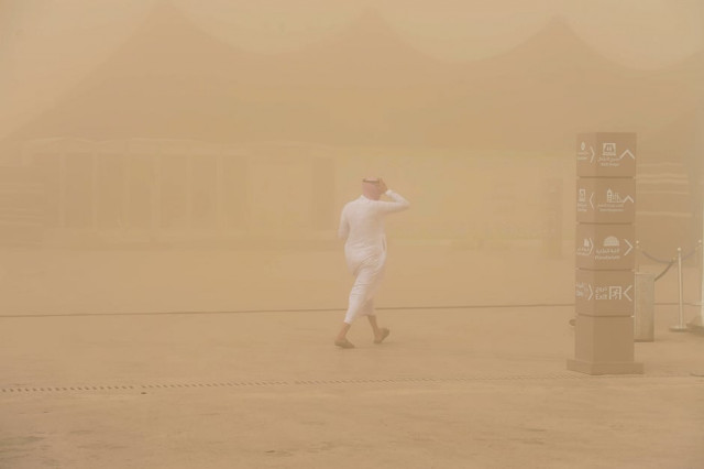 a saudi man walks in a sand storm during the annual king abdulazziz camel festival in rumah some 150 kilometres east of riyadh photo afp