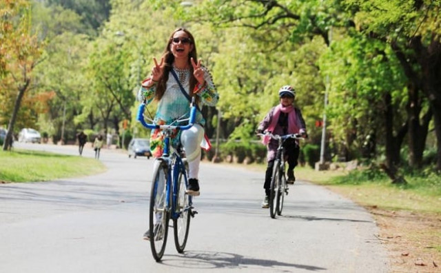 a woman flashes victory signs as she rides a bicycle during girls on bike rally in islamabad pakistan april 2 2017 photo reuters a woman flashes victory signs as she rides a bicycle during girls on bike rally in islamabad pakistan april 2 2017 photo reuters