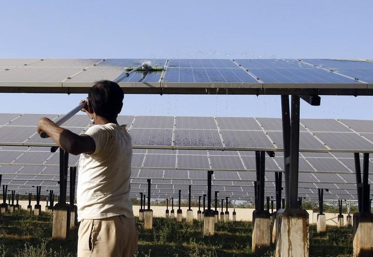 a worker cleans photovoltaic solar panels inside a solar power plant at raisan village near gandhinagar in gujarat february 11 2014 photo reuters