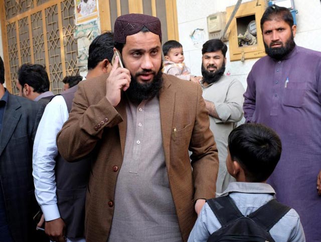 masroor nawaz jhangvi a cleric whose father was one of the most infamous sectarian figures uses his mobile phone while meeting residents in jhang december 16 2016 photo reuters