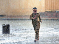 a young boy runs to seek shelter during heavy rainfall in rawalpindi photo app