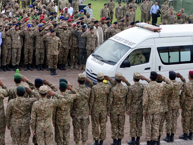 armymen pay respect as an ambulance carrying the coffins of martyred soldiers passes through photo afp