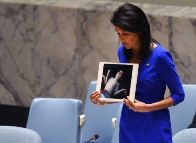 us ambassador to the un nikki haley holds photos of victims as she speaks at the un security council on april 5 2017 photo afp us ambassador to the un nikki haley holds photos of victims as she speaks at the un security council on april 5 2017 photo afp