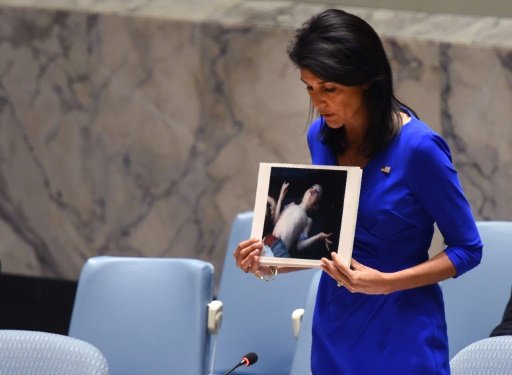 us ambassador to the un nikki haley holds photos of victims as she speaks at the un security council on april 5 2017 photo afp