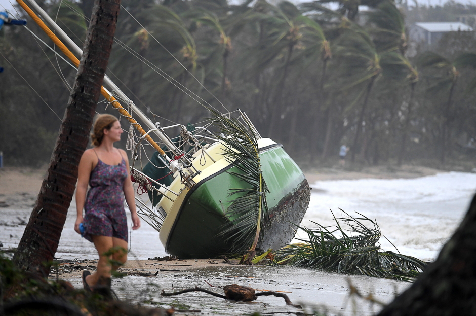 a woman walks past a yacht that was washed ashore after cyclone debbie hit the northern queensland town of airlie beach located south of townsville in australia photo reuters