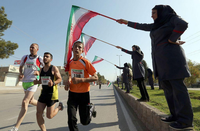 iranian women wave their national flag as they support iranian and foreign runners competing in iran 039 s first internation marathon in marvdasht on april 9 2016 photo afp iranian women wave their national flag as they support iranian and foreign runners competing in iran 039 s first internation marathon in marvdasht on april 9 2016 photo afp