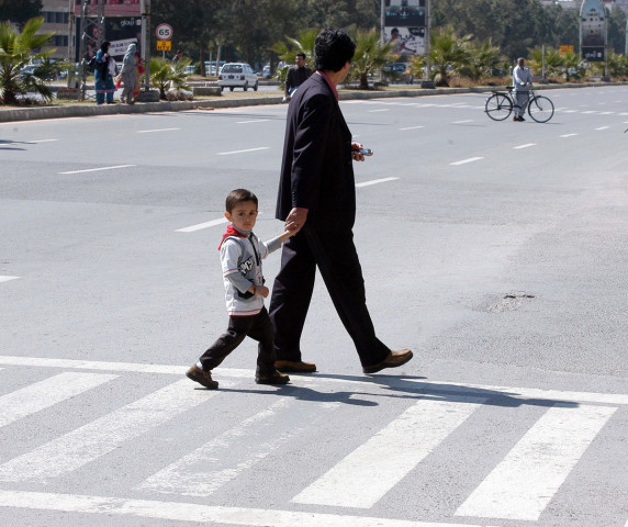 a boy and his father walk over a zebra crossing photo muhammad javaid a boy and his father walk over a zebra crossing photo muhammad javaid