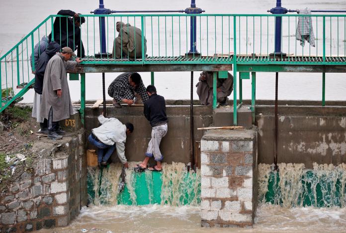 people try to stop water flowing through the gate of a flood channel after incessant rains in srinagar april 7 2017 photo reuters