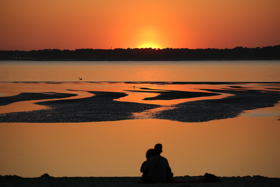 people watch the sunset on the cap ferret from a beach of the arcachon bay photo afp