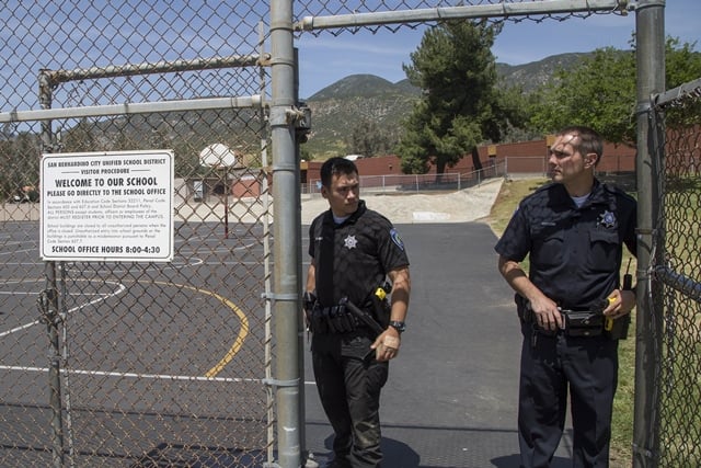 san bernardino police offers stand guard at north park elementary school following a shooting on campus photo afp