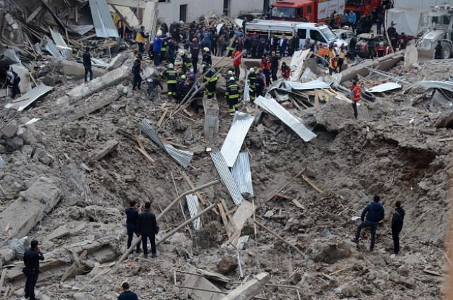 people and emergency workers stand at the site of a strong blast near the riot police headquarters in the center of diyarbakir southeastern turkey on april 11 2017 photo afp people and emergency workers stand at the site of a strong blast near the riot police headquarters in the center of diyarbakir southeastern turkey on april 11 2017 photo afp