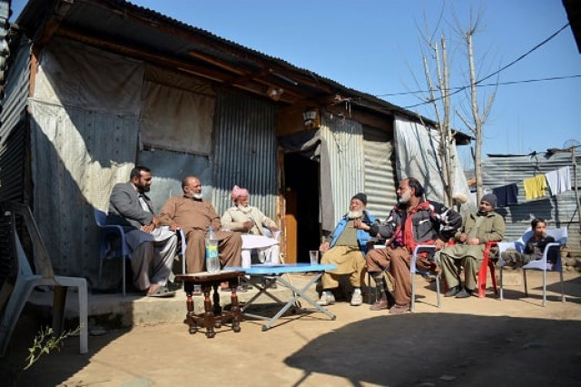 this photograph taken on february 12 2017 shows elderly indian kashmiri muhammad ashraf 2l flanked by his son muhammad asghar l as he meets with his childhoood friend muhammad sharif r upon his arrival at a refugee camp on the outskirts of muzaffarabad photo afp this photograph taken on february 12 2017 shows elderly indian kashmiri muhammad ashraf 2l flanked by his son muhammad asghar l as he meets with his childhoood friend muhammad sharif r upon his arrival at a refugee camp on the outskirts of muzaffarabad photo afp
