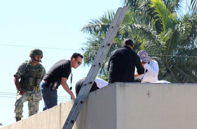a soldier stands guard as forensic technicians work at a crime scene where the body of a man who witnesses said was tossed from a plane landed on a hospital roof in culiacan in mexico 039 s northern sinaloa state april 12 2017 photo reuters