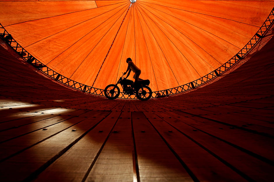 a stuntman rides a motorcycle inside the quot well of death quot attraction during a fair in bhaktapur nepal photo reuters