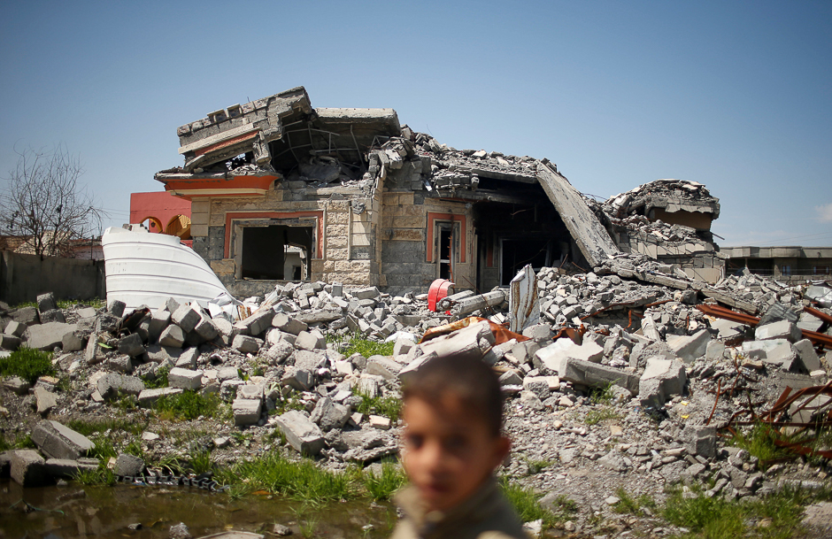 an iraqi boy walks past a building destroyed during the fighting between iraqi forces and islamic states militants in qayyara iraq photo reuters