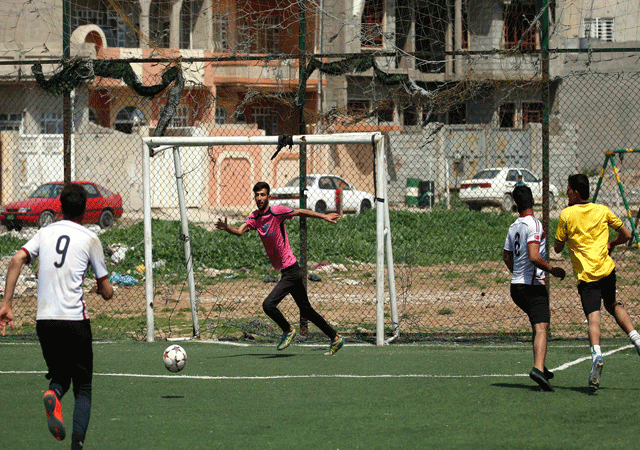 a goalkeeper attempts to stop a shot during a football match in eastern mosul 039 s al salam neighbourhood on april 7 2017 photo afp