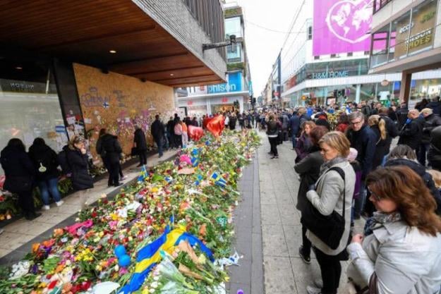 people lay flowers near the crime scene at ahlens department store in drottninggatan in stockholm photo reuters