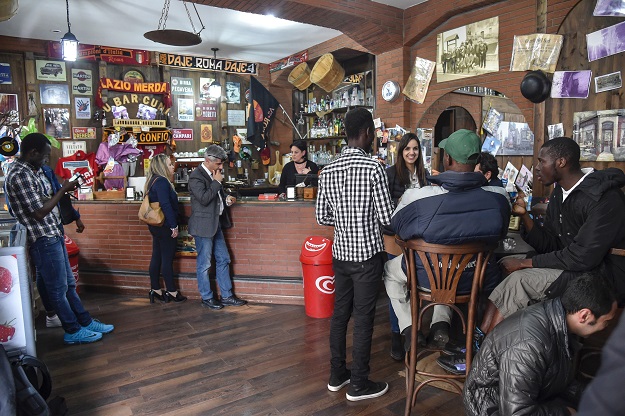 migrants and residents stand in the main bar of sant 039 alessio in aspromonte a small village of 330 inhabitants in calabria southern italy on april 6 2017 photo afp