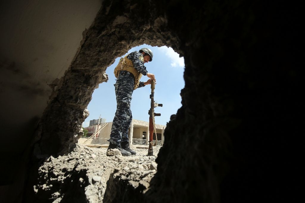 a member of the iraqi forces reloads a rocket propelled grenade during clashes with islamic state group fighters in the old city of mosul photo afp