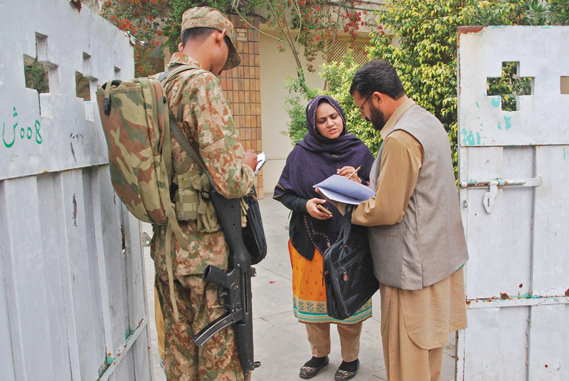 an enumerator along with a soldier collects information in lahore photo express