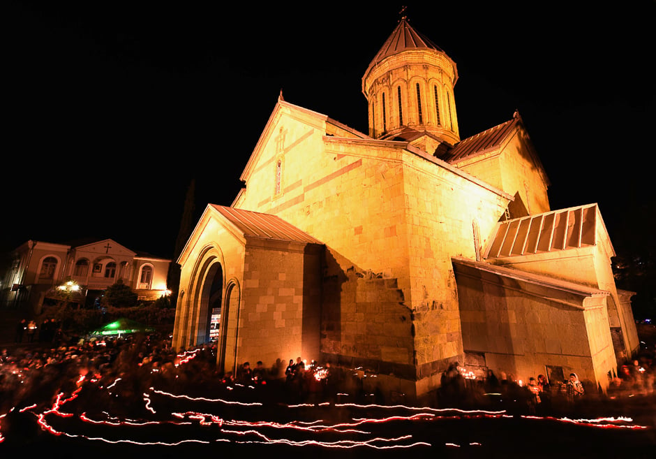 worshippers walk around the sioni cathedral holding lit candles during a midnight easter service in tbilisi photo afp