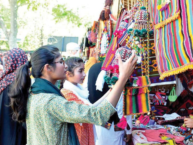 women try out traditional purses and jewellery while performers at the lok mela enthrall the audience photo online women try out traditional purses and jewellery while performers at the lok mela enthrall the audience photo online