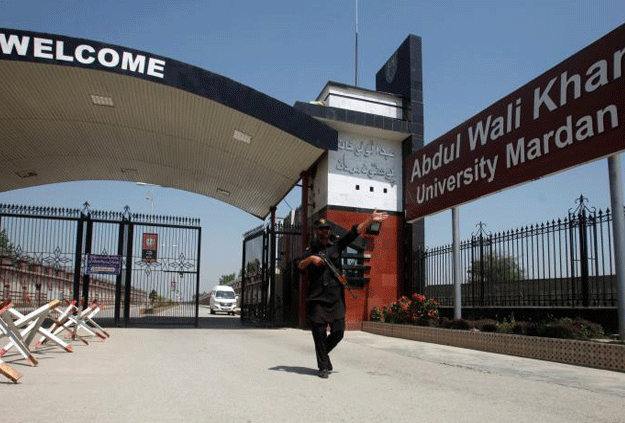 a policeman gestures as he stands guard at the entry of abdul wali khan university where mashal khan accused of blasphemy was killed by a mob in mardan april 14 2017 photo reuters