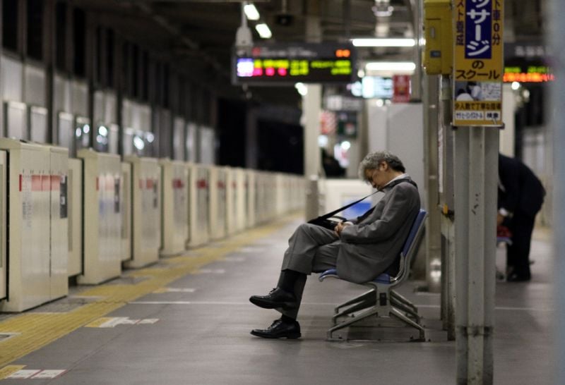 a businessman is seen napping on a bench at a tokyo train station photo afp