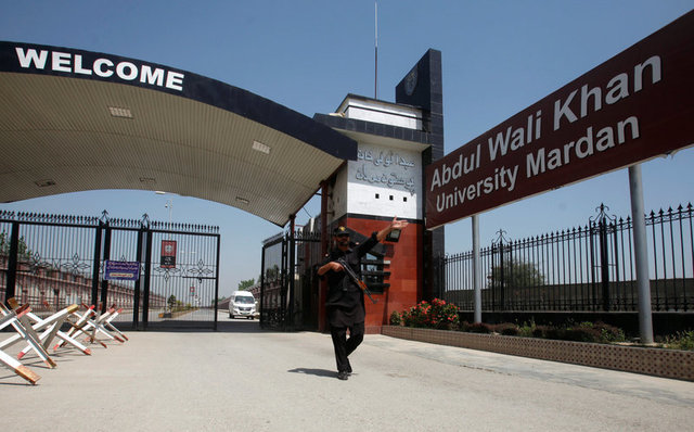 a policeman gestures as he stands guard at the entry of abdul wali khan university where mashal khan accused of blasphemy was killed by a mob in mardan on april 14 2017 photo reuters