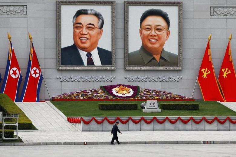 a man walks in front of portraits of north korea founder kim il sung and late leader kim jong il in central pyongyang north korea april 16 2017 photo reuters