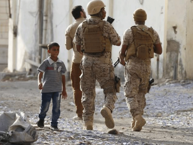 a boy walks past soldiers from the saudi led coalition patrolling a street in yemen 039 s southern port city of aden september 26 2015 photo reuters