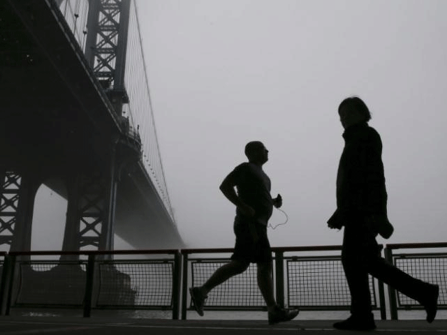 people are seen in silhouette exercising under the fog covered manhattan bridge in new york december 14 2015 photo reuters