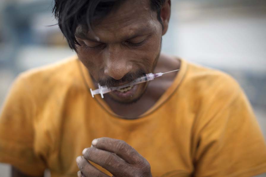 in this file photo an addict prepares to inject himself with drugs photo afp
