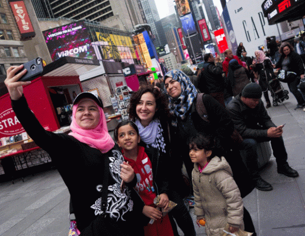 syrian and iraqi refugee families take selfies in times square during a tour of manhattan in new york photo afp syrian and iraqi refugee families take selfies in times square during a tour of manhattan in new york photo afp