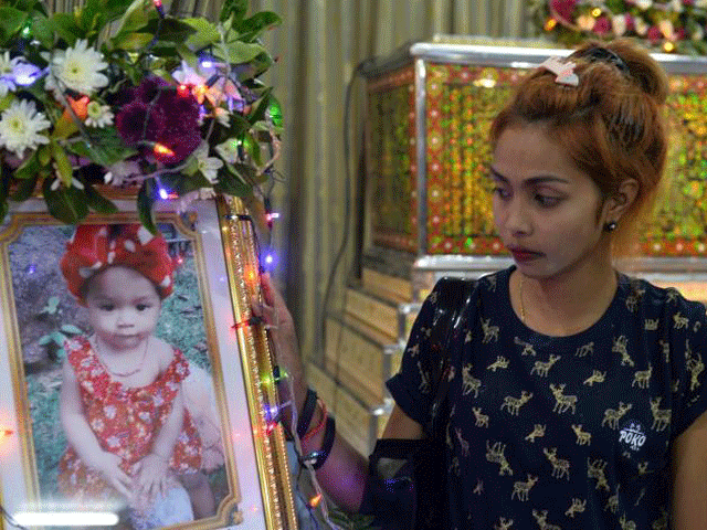 jiranuch trirat mother of 11 month old daughter who was killed by her father who broadcast the murder on facebook stands next to a picture of her daughter at a temple in phuket thailand april 25 2017 photo reuters