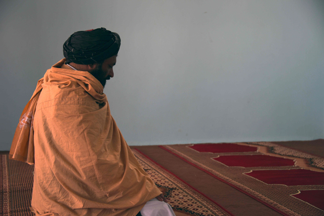 in this photograph taken on march 22 2017 former afghan taliban commander maulvi abdul rauf 37 offers prayers inside a mosque in the panjwayi district of kandahar province photo afp