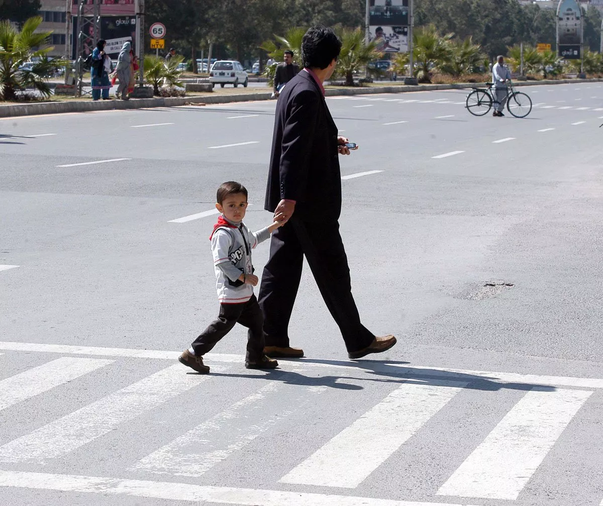 a boy and his father walk over a zebra crossing photo muhammad javaid a boy and his father walk over a zebra crossing photo muhammad javaid