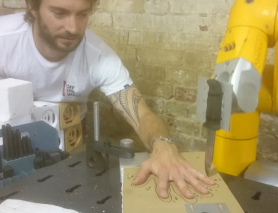 man plays the five finger fillet with a robot arm